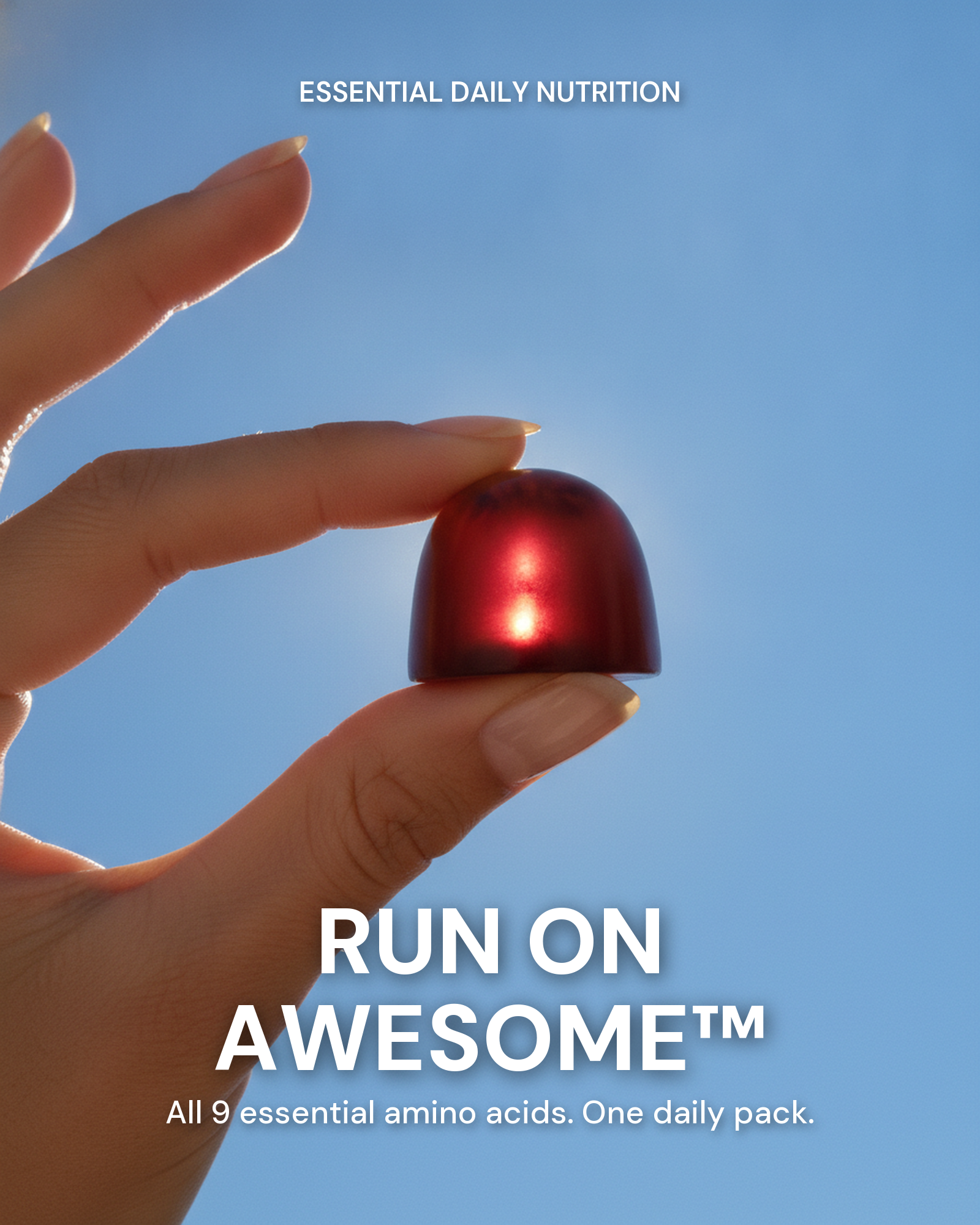A hand holding an Awesome Everyday gummy up to a blue sky — Run On Awesome