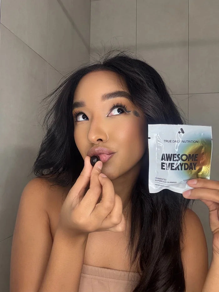 A customer taking an Awesome Everyday gummy