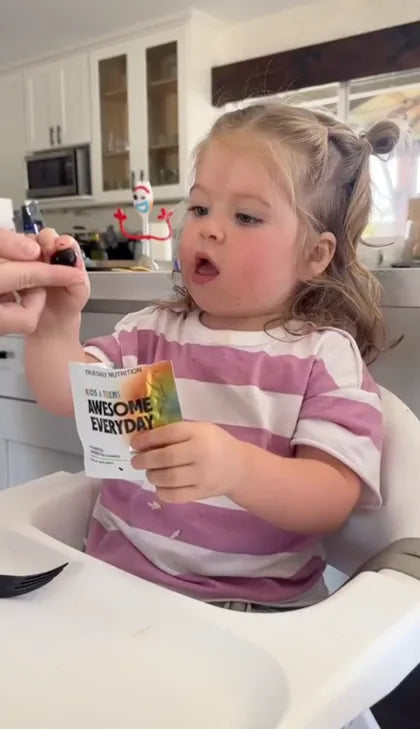 A toddler reaching for a gummy