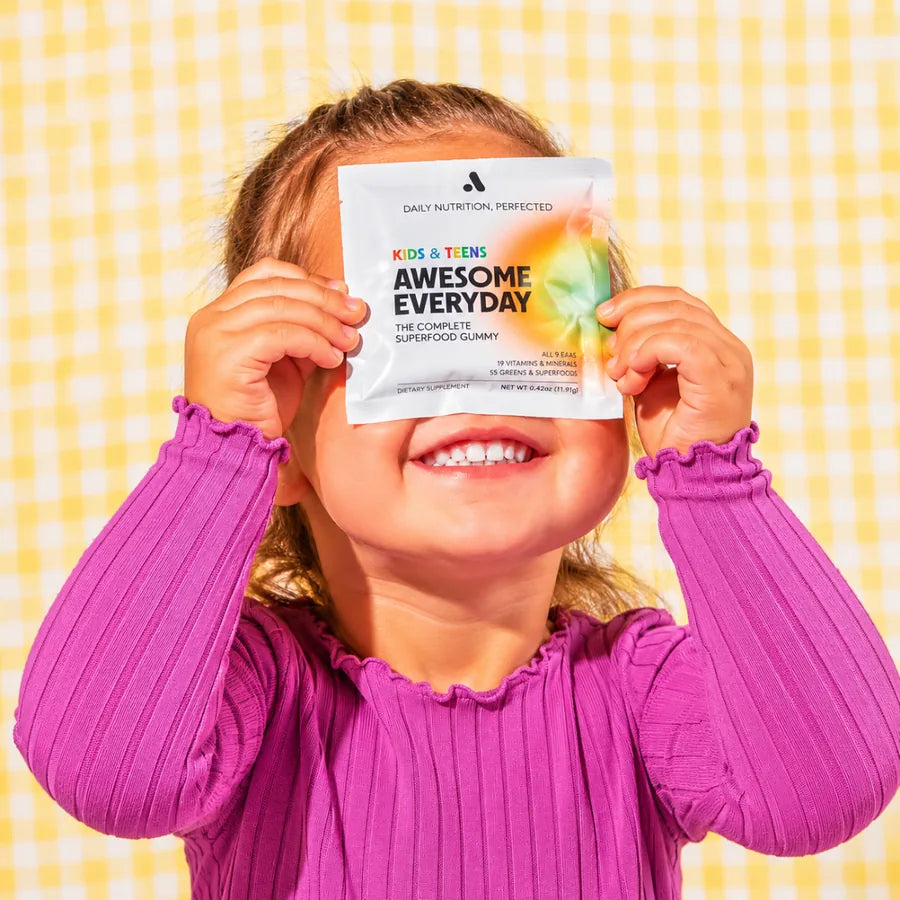 A child holding an Awesome Everyday pack over her eyes